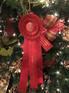A red ribbon award on a christmas tree